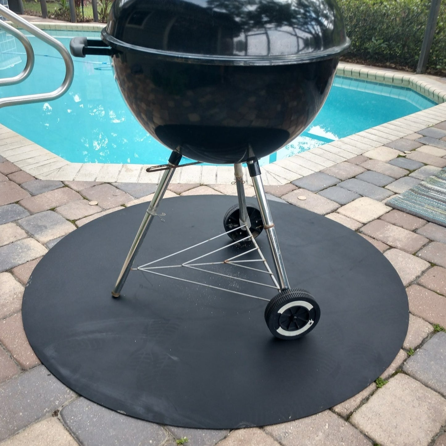 a photo of the mat with a charcoal grill on top of it by a pool