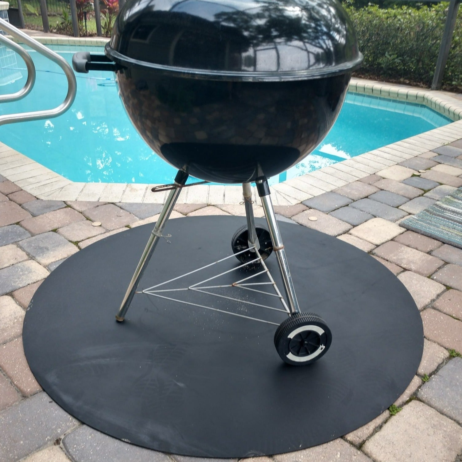 a photo of the mat with a charcoal grill on top of it by a pool